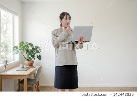 A woman is surprised when she looks at her laptop at home. A woman is surprised when she looks at her laptop at home. 142448826