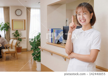 養老院裡，一名身穿白大褂的女工作人員舉起食指。 142448855