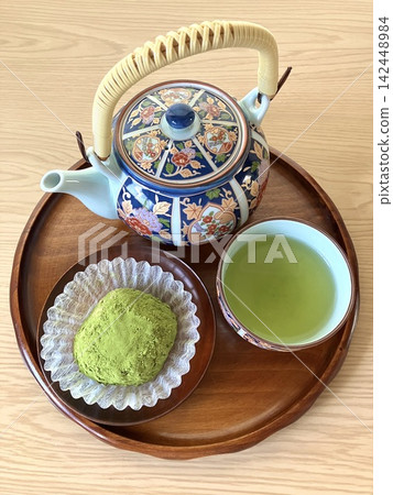 從高空俯瞰,可以看到一個托盤,上面放著抹茶大萩(年糕)和一壺綠茶。 從高空俯瞰,可以看到一個托盤,上面放著抹茶大萩(年糕)和一壺綠茶。 142448984