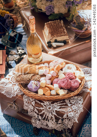 Closeup of picnic basket with drinks, food and flowers Closeup of picnic basket with drinks, food and flowers 142449168