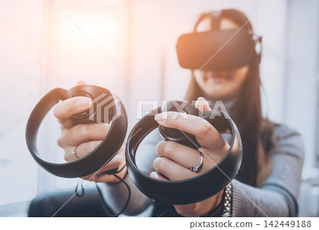 The beautifull girl playing games with virtual reality goggles The beautifull girl playing games with virtual reality goggles 142449188
