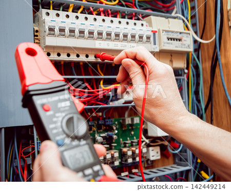 Electrical equipment. Tester in the hands. Background and texture Electrical equipment. Tester in the hands. Background and texture 142449214