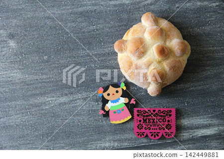 Mexican sweet bread with coffee in a talavera cup, pan de muerto, papel picado and traditional Mexican skulls Mexican sweet bread with coffee in a talavera cup, pan de muerto, papel picado and traditional Mexican skulls 142449881