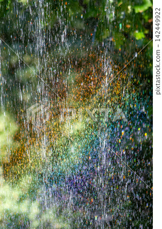 Colorful rainbow light refraction in water spray over green oak leaves Colorful rainbow light refraction in water spray over green oak leaves 142449922