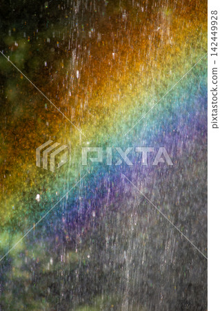 Vibrant rainbow light spectrum refracting through dense water spray droplets outdoors Vibrant rainbow light spectrum refracting through dense water spray droplets outdoors 142449928