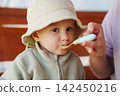 Cose-up of a Toddler Eating Baby Food from a Spoon 142450216