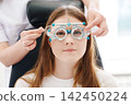 Doctor changing lens in diagnostic trial frame close-up 142450224