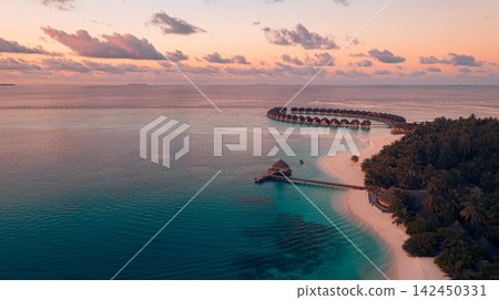 Spectacular aerial view overwater villas curving vivid azure Maldives lagoon lush palm island luxury resort. Luxury travel destination landscape scenic. Exotic honeymoon getaway vista wallpaper Spectacular aerial view overwater villas curving vivid azure Maldives lagoon lush palm island luxury resort. Luxury travel destination landscape scenic. Exotic honeymoon getaway vista wallpaper 142450331