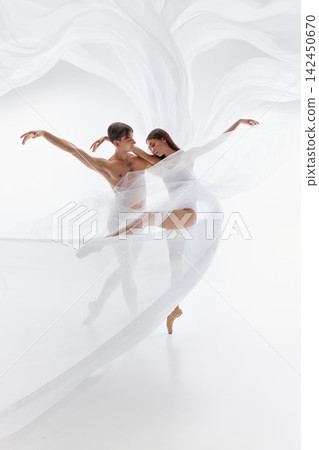 Flowing textile surrounds ballet partners in synchronized studio movement Flowing textile surrounds ballet partners in synchronized studio movement 142450670
