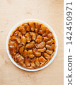 Traditional homemade French apple tarte tatin on white plate over wooden background 142450971