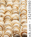 Raw homemade handmade russian pelmeni dumplings rows sprinkled with flour on metal tray 142450980