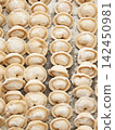 Raw homemade handmade russian pelmeni dumplings rows sprinkled with flour on metal tray 142450981
