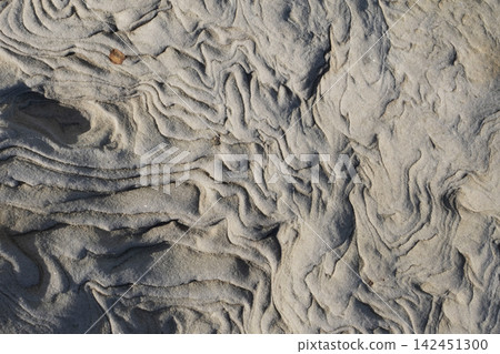 Sandstone rock showing natural ripple patterns formed by erosion over time Sandstone rock showing natural ripple patterns formed by erosion over time 142451300