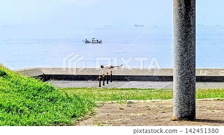 在防波堤上曬日光浴 在防波堤上曬日光浴 142451380