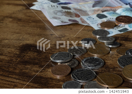 British coins and banknotes on wooden table 142451943