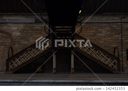 Railway station platform with pedestrian bridge stairs, architecture and stone wall in Perth, Scotland Railway station platform with pedestrian bridge stairs, architecture and stone wall in Perth, Scotland 142452353
