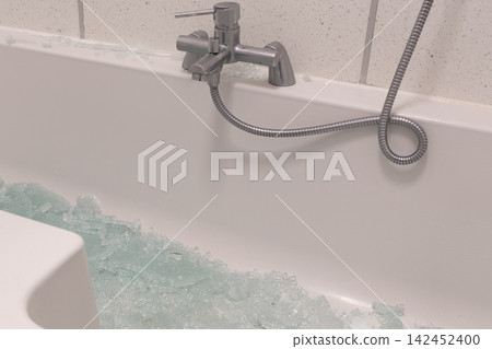 Bathtub filled with shattered glass from a broken shower screen after an accident Bathtub filled with shattered glass from a broken shower screen after an accident 142452400