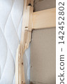 Broken wooden bed frame showing damaged timber and splintered wood structure 142452802