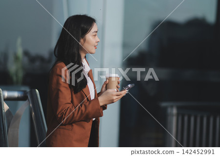 Young businesswoman smiling while working with digital tablet at modern office building Young businesswoman smiling while working with digital tablet at modern office building 142452991