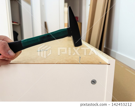 Hammer over a nail in the hardboard back of a tall cabinet Hammer over a nail in the hardboard back of a tall cabinet 142453212