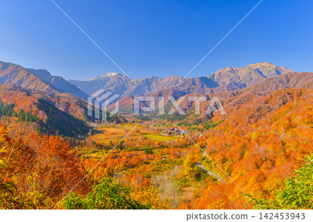 On a clear autumn morning, Mount Echigo-Komagatake and Mount Nakanodake can be seen beyond the forest park and hot spring town surrounded by the autumn foliage of Ginzan-daira. On a clear autumn morning, Mount Echigo-Komagatake and Mount Nakanodake can be seen beyond the forest park and hot spring town surrounded by the autumn foliage of Ginzan-daira. 142453943