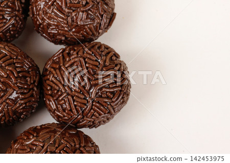 Traditional Brazilian chocolate brigadeiros coated in sprinkles, set against a white background with copy space. Traditional Brazilian chocolate brigadeiros coated in sprinkles, set against a white background with copy space. 142453975