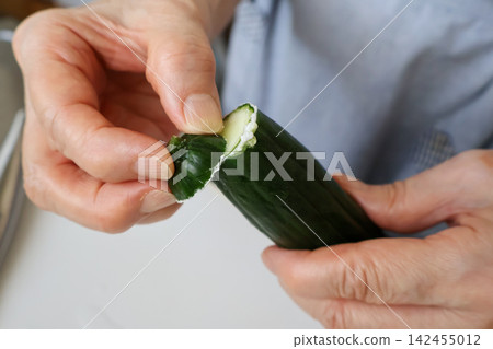 特寫:一位老婦人正在用手去除黃瓜上的苦味。 特寫:一位老婦人正在用手去除黃瓜上的苦味。 142455012