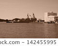 A sepia-toned landscape of destroyers and submarines anchored in Yokosuka Port. 142455995