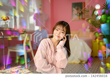 A woman smiling in a pink room A woman smiling in a pink room 142456016