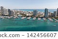 Yacht docked at Miami marina. Aerial view of coastline in Miami. Miami skyline above harbor. Famous Miami Beach marine from above. Marina with yachts. 142456607