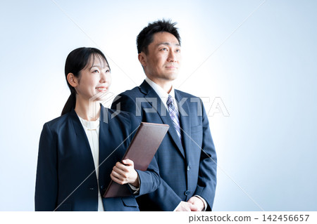 Female and male employees in suits, smiling and looking towards the future. 142456657