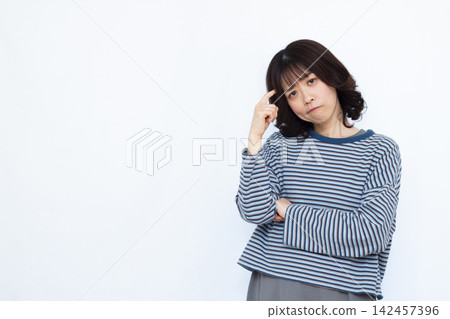 A woman holding her head in worry A woman holding her head in worry 142457396