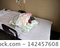 A pile of beds and bedding in a room at a nursing home. 142457608