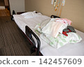 A pile of beds and bedding in a room at a nursing home. 142457609
