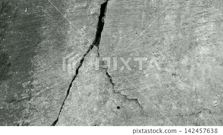 A monochromatic view of branching cracks on a weathered concrete surface. A monochromatic view of branching cracks on a weathered concrete surface. 142457638