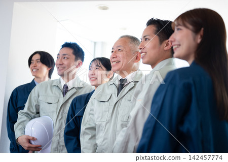 A team of construction workers looking towards the future with smiles on their faces. A team of construction workers looking towards the future with smiles on their faces. 142457774
