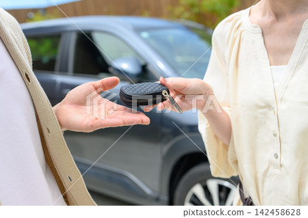 Husband receives car keys from wife Husband receives car keys from wife 142458628