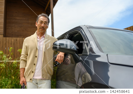 A man leaning against a car A man leaning against a car 142458641