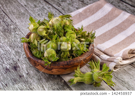 Bowl of fresh green hazelnuts or cobnuts on rustic wooden table Bowl of fresh green hazelnuts or cobnuts on rustic wooden table 142458937