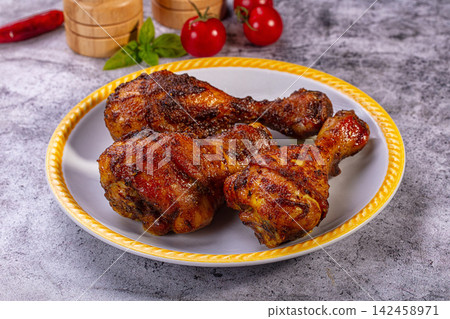 Roasted chicken drumsticks on yellow rimmed plate with cherry tomatoes and basil Roasted chicken drumsticks on yellow rimmed plate with cherry tomatoes and basil 142458971