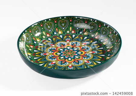 Green ceramic bowl with intricate floral mandala pattern and vibrant colors 142459008