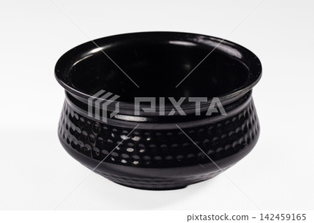 Black ceramic bowl with textured dotted pattern on white background Black ceramic bowl with textured dotted pattern on white background 142459165