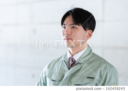 A young male employee, dressed in work clothes and a tie, with a serious expression on his face. A young male employee, dressed in work clothes and a tie, with a serious expression on his face. 142459243