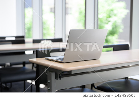 A desk with a closed laptop on it. A desk with a closed laptop on it. 142459505