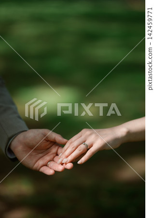 Couple's hands and rings Couple's hands and rings 142459771