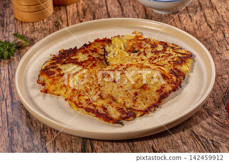 Crispy golden potato pancakes on ceramic plate with rustic wooden background Crispy golden potato pancakes on ceramic plate with rustic wooden background 142459912