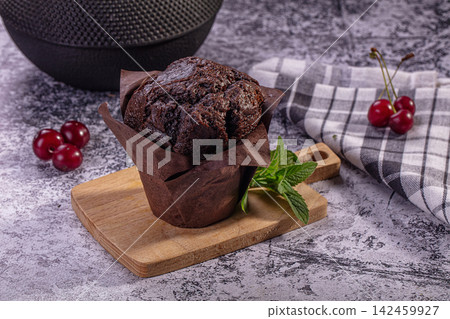Chocolate muffin on wooden board with fresh cherries and mint Chocolate muffin on wooden board with fresh cherries and mint 142459927