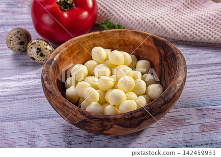 Scamorza cheese balls in wooden bowl with tomato and quail eggs on rustic table Scamorza cheese balls in wooden bowl with tomato and quail eggs on rustic table 142459931