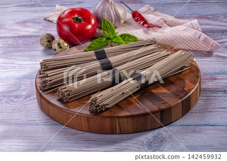 Soba noodles on wooden board with tomato garlic basil and quail eggs Soba noodles on wooden board with tomato garlic basil and quail eggs 142459932
