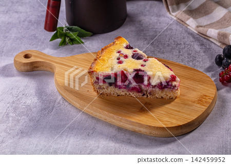 Slice of berry pie on wooden board with fresh blueberries and red currants Slice of berry pie on wooden board with fresh blueberries and red currants 142459952